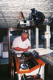 Copyright Victoria Brooks. Caption: The owner, Bob Clark, charts a course. 
