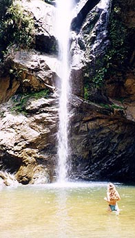Tracey wades into to the chilly waterfall. Copyright: Jennifer Hile.