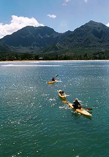 Copyright Jim Johnson. Micco Godinez, owner of Kayak Kauai Outbound, leads a small flotilla off Hanalei Beach. 