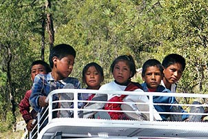 Children in a remote Mexican village catch a ride to school atop a van. Copyright: Kathryn Means.
