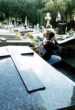 A backpacker takes photos of singer Edith Piaf's family monument. Copyright: Kathryn Means